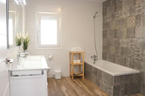 biała łazienka z wanną i umywalką w obiekcie APARTAMENTOS RURALES ( LA COBIJÁ) APART Nº2 CONIL w mieście Conil de la Frontera