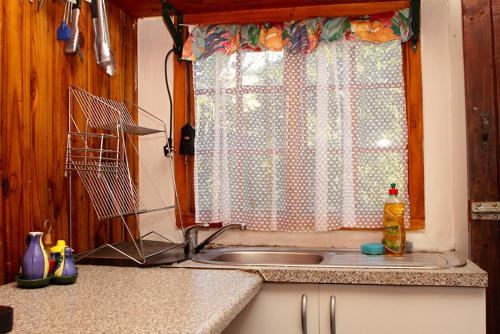 a kitchen with a sink and a window at Treehouse River Lodge in Elangeni