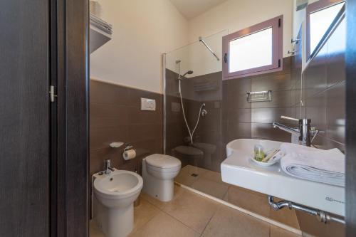 uma casa de banho com um WC, um lavatório e um chuveiro em Corte dei Melograni Hotel Resort em Otranto