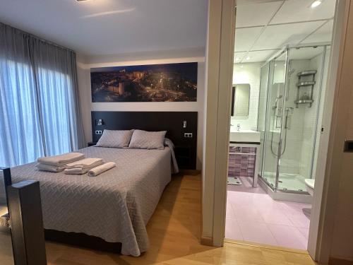 um quarto com uma cama e uma casa de banho com um chuveiro em Precioso dúplex en el centro de Tarragona em Tarragona