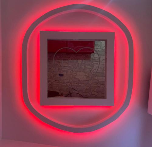 una cornice con luci rosse su un muro di Maison Rinaldi SrL a Bari