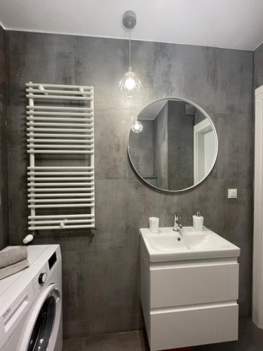 a bathroom with a sink and a mirror and a washing machine at N° 60 in Płock