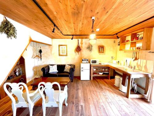 a kitchen with wooden ceilings and a table and chairs at vintagehouse1925Bali - Vacation STAY 14503 in Nagano