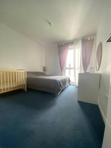 une chambre avec un lit et une grande fenêtre dans l'établissement Construit en 2020, 82m2, entre paris et disney, à Noisy-le-Grand