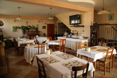 ヴジェシニャにあるWilla Wiosnaの白いテーブルクロスのテーブルと椅子が備わるレストラン