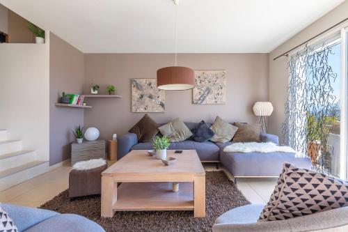 a living room with a blue couch and a table at Villa proche Annecy in Lovagny