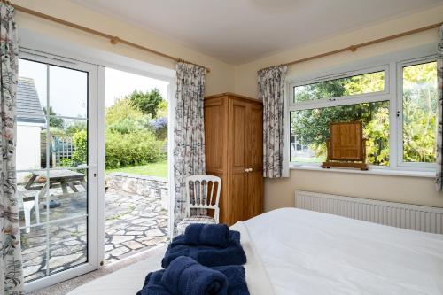 a bedroom with a bed and a sliding glass door at Pencreek in Padstow