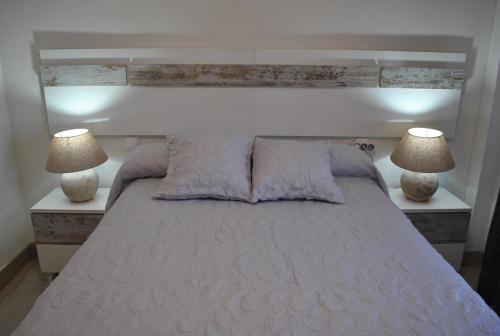 a bedroom with a large bed with two lamps at Viviendas De Uso Turistico Rocinante TOLEDO in Toledo