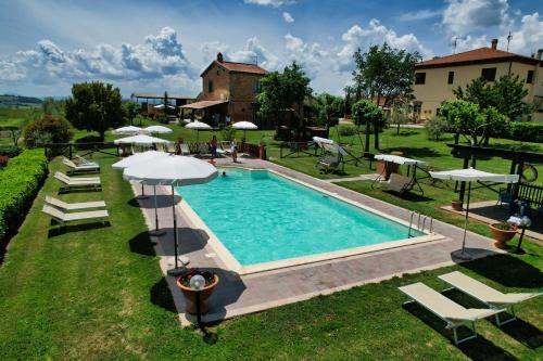 una piscina con sedie e ombrelloni in un cortile di Agriturismo San Francesco a Cortona