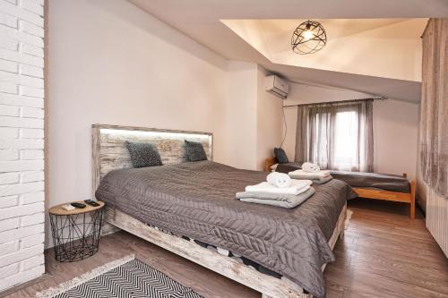 a bedroom with a large bed with two towels on it at Zmaj Ognjeni Etno Concept in Kupinovo