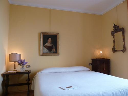 a bedroom with a bed and a portrait of a woman at B&B Casa Forster in Cannero Riviera
