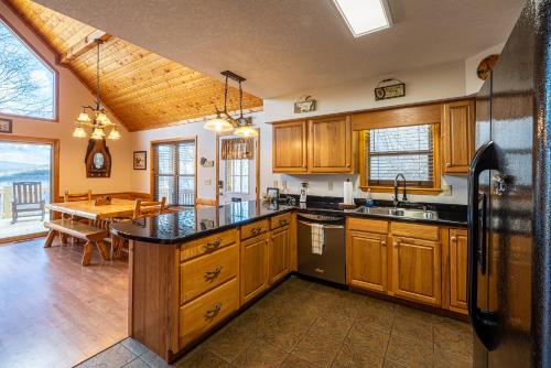 a kitchen with wooden cabinets and a dining room with a table at Ridgetop Lakeview Retreat - 4 Bedroom Cabin with Private Deck Overlooking Lake Nantahala in Topton