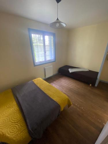 a bedroom with two beds and a window at Manot Vacances - Gites en bord de Vienne in Manot