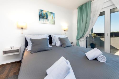 een slaapkamer met een groot bed en een groot raam bij Grand Suite Cocaletto 2 in Rovinj