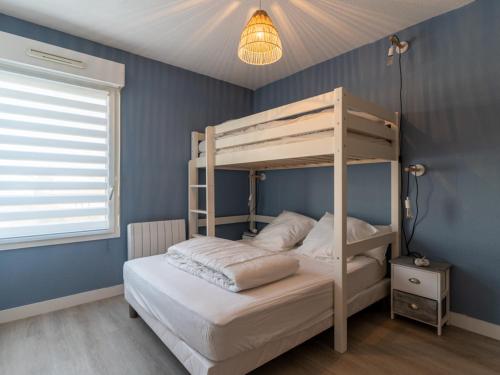 a bedroom with a bunk bed and a blue wall at Appartement T3 rénové face à la dune, 6 pers., piscine, plage à pied - Biscarrosse - FR-1-319-489 in Biscarrosse