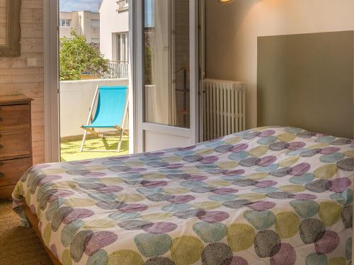 - une chambre avec un lit et une chaise sur un balcon dans l'établissement Appartement T3 avec Terrasse, Proche Plage et Commerces à Larmor-Plage - FR-1-349-199, à Larmor-Plage