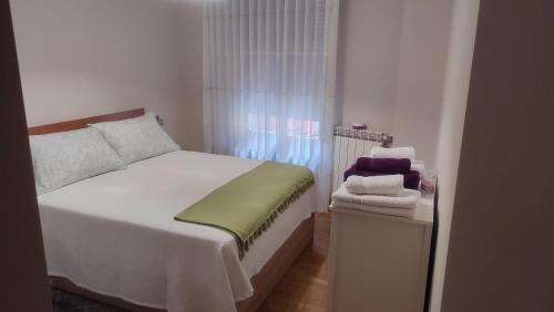 a small bedroom with a white bed and a window at Estudio Paloma in León