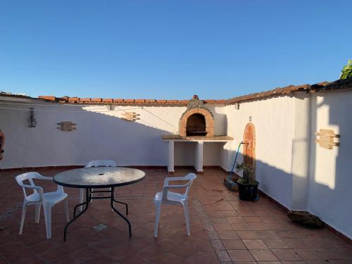 a patio with a table and chairs and a pizza oven at APARTAMENTO TURÍSTICO EL ESQUILÓN in Calzadilla