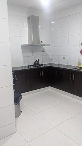 eine Küche mit schwarz-weißen Wänden und weißem Boden in der Unterkunft Moderno Departamento Céntrico c/ Wifi Empresarial in Tarija