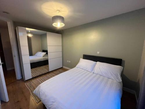 a bedroom with a large white bed and a mirror at Pettit Apartments - Central "Free Parking" in Liverpool