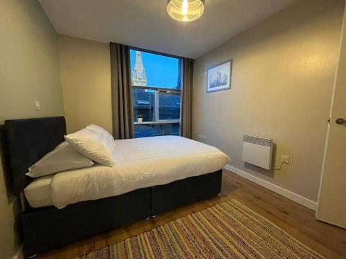 a bedroom with a bed with a large window at Pettit Apartments - Central "Free Parking" in Liverpool