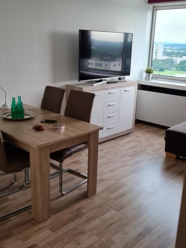 ein Wohnzimmer mit einem Tisch und einem Flachbild-TV in der Unterkunft IM SI-CENTRUM 2 ZIMMER APART#MUSICAL#MESSE#Flughafen in Stuttgart
