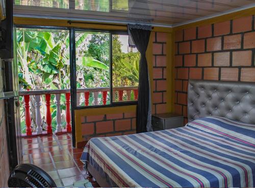 a bedroom with a bed in a room with windows at Finca Villa Hermosa in Alcalá
