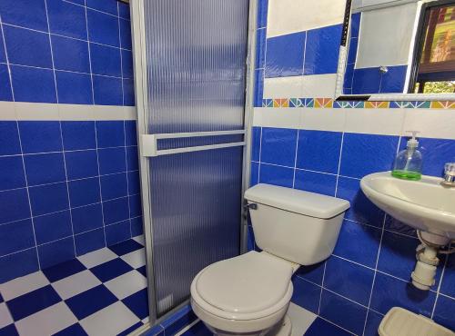 a blue tiled bathroom with a toilet and a sink at Finca Villa Hermosa in Alcalá