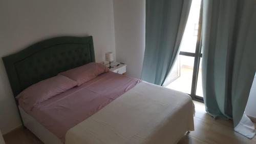 een slaapkamer met een bed met een roze kussen erop bij Villa-Hotel Ludianna in Golem