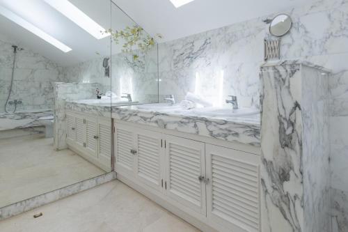 ein Badezimmer mit 2 Waschbecken und weißen Marmorwänden in der Unterkunft PIZARRA Planetcostadorada in Tarragona