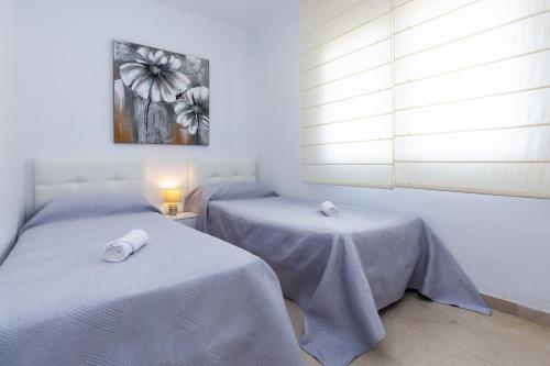 2 Betten in einem Zimmer mit weißen Wänden in der Unterkunft PIZARRA Planetcostadorada in Tarragona