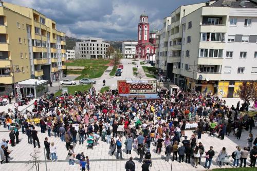 a large crowd of people walking down a city street at Stan na dan Lorena in Sarajevo