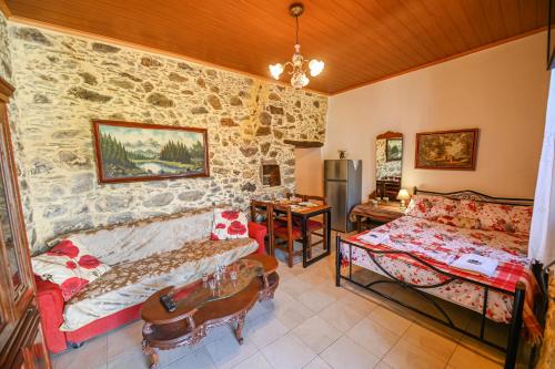 Stone house for relaxation in Elos في كيساموس: غرفة معيشة مع جدار حجري