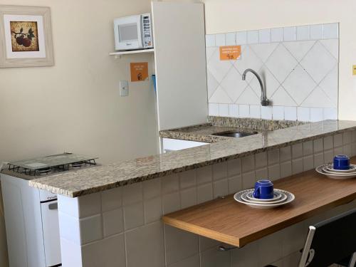 a kitchen with a counter with blue cups and plates at Apart Victoria in Vitória da Conquista