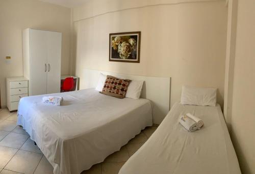 a bedroom with two beds in a room at Apart Victoria in Vitória da Conquista