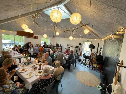 een groep mensen die aan tafel zitten in een restaurant bij Room 16 - Hawkraft kulturhotel in Vestervig