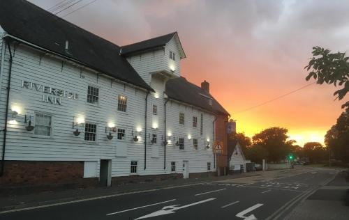 a building on a street with the sunset in the background at The Riverside Inn in Chelmsford