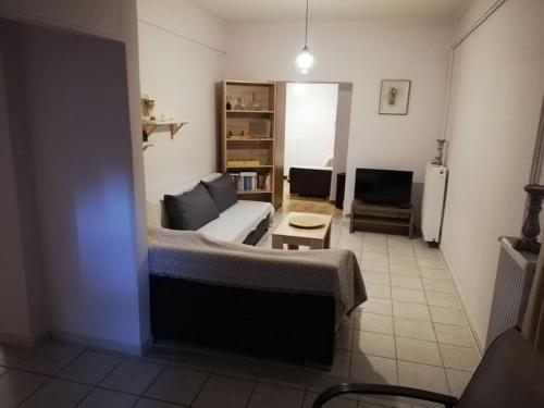 een woonkamer met een bank en een tafel bij Comfortable apartment for relax. in Volos
