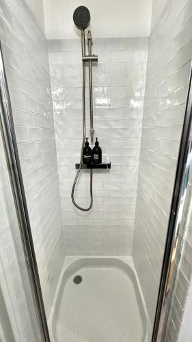 a bathroom with a shower and a bath tub with a sink at Studio Douillet Hypercentre 12 min de Paris in Enghien-les-Bains