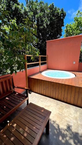a hot tub with a wooden fence and a bench at Pousada Pipa Soul in Pipa
