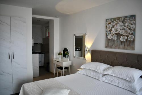a bedroom with a bed and a sink and a mirror at Draga & Lola in Baška Voda