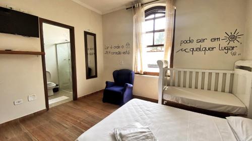 1 dormitorio con 1 cama y 1 silla azul en Namoa Pollastrini, en Itanhaém