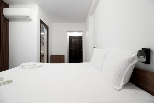 a bedroom with a white bed with white pillows at Бялата Къща 2 in Zlatograd
