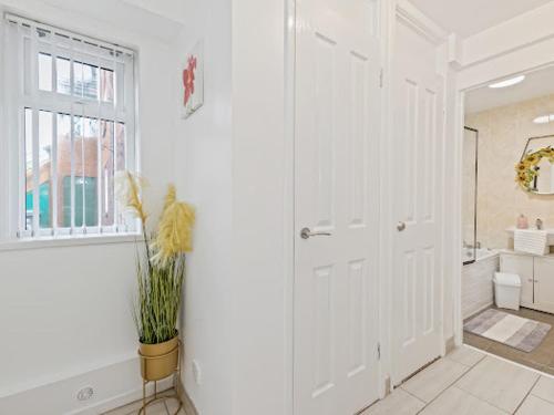 a large white bathroom with a tub and a window at Self Catering Belfast Apartment in Belfast