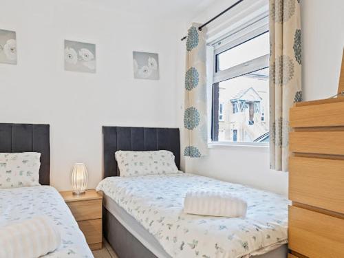 a bedroom with two beds and a window at Self Catering Belfast Apartment in Belfast
