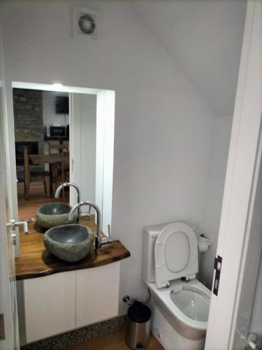 een badkamer met een wastafel, een toilet en een spiegel bij Casa do passadiço in Vieira do Minho