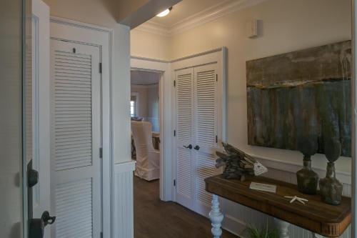 a hallway with white doors and a painting on the wall at Lighthouse Loft in Santa Rosa Beach