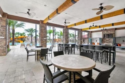 un restaurant avec des tables et des chaises et une terrasse dans l'établissement Summer Breeze Villa, à Davenport