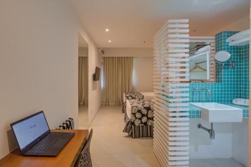 リオデジャネイロにあるRio Design Copacabana Hotelのノートパソコン付きのデスク、バスルームが備わる客室です。