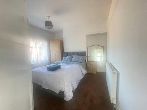 biała sypialnia z łóżkiem i lustrem w obiekcie West Bishop Auckland Professional Let w mieście Bishop Auckland